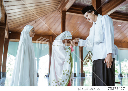 portrait of girls kissing the hand of a male Muslim teacher before returning to home portrait of girls kissing the hand of a male Muslim teacher before returning to home 75878427