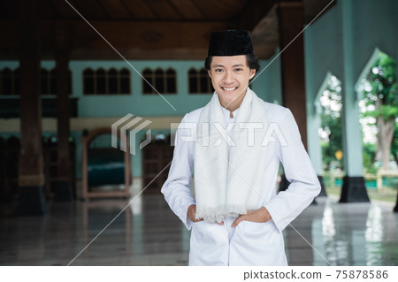 Portrait young man Muslim standing and placing his hands in his pocketse 75878586