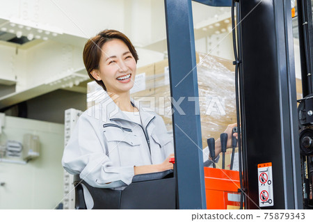 Woman operating a forklift Woman operating a forklift 75879343