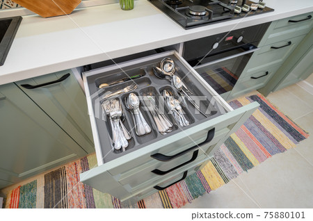 Drawer pulled out in cabinet at luxury teal and white modern kitchen furniture 75880101