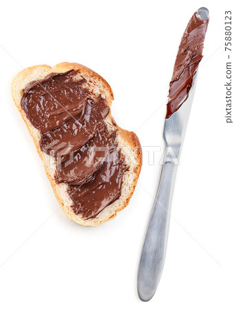 Piece of bread with chocolate paste and knife on white background, isolated. Top view 75880123