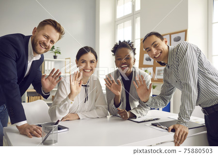Team of business people waving hello at camera greeting international coworkers in online meeting Team of business people waving hello at camera greeting international coworkers in online meeting 75880503