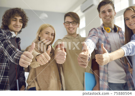 Group of happy college students who have passed all their exams giving thumbs-up Group of happy college students who have passed all their exams giving thumbs-up 75880504