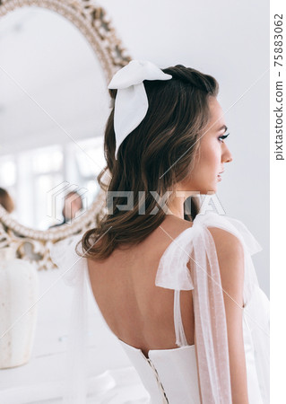 Close-up of beautiful stylish bride with an elegant hairstyle view from the back . Studio shot Close-up of beautiful stylish bride with an elegant hairstyle view from the back . Studio shot 75883062