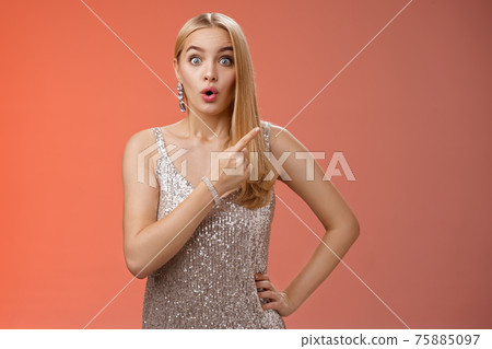 Wondered amused attractive blond woman talking party widen eyes say wow pointing questioned right direction see famous person standing surprised impressed gaze camera, red background Wondered amused attractive blond woman talking party widen eyes say wow pointing questioned right direction see famous person standing surprised impressed gaze camera, red background 75885097