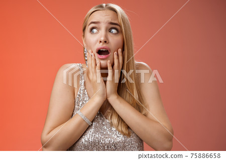 Afraid girl panic look left scared trembling fear insecure touching cheeks helpless stare sideways grimacing gasping frightened nervously waiting help, standing concerned red background 75886658