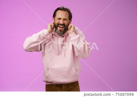 Annoyed fed up pressured caucasian adult man bearded yelling pissed close eyes cringing disgust annoyance close ears bothered cannot stand loud awful noise, grimacing shouting turn off music 75887099