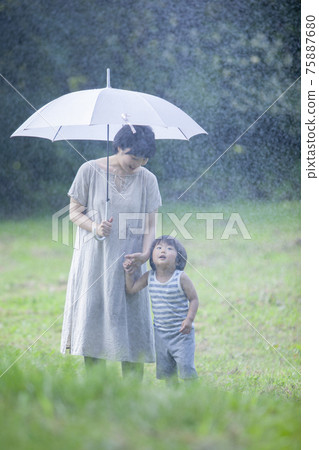 Parents and children walking with an umbrella on a rainy day Parents and children walking with an umbrella on a rainy day 75887680