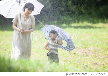Parents and children walking with an umbrella on a rainy day Parents and children walking with an umbrella on a rainy day 75887724