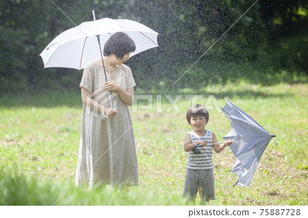 Parents and children walking with an umbrella on a rainy day Parents and children walking with an umbrella on a rainy day 75887728