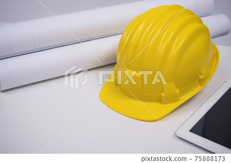 Yellow helmet and rolled paper. Yellow helmet and rolled paper. 75888173