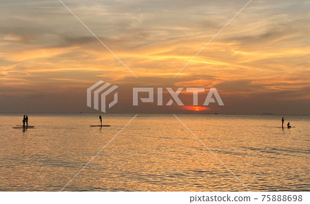 Silhouette of Stand Up Paddle board on the beach at sunset. Surfer and ocean. Side view. Silhouette of Stand Up Paddle board on the beach at sunset. Surfer and ocean. Side view. 75888698