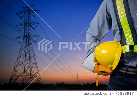 Engineer holding yellow helmet with Transmission tower. 75888917