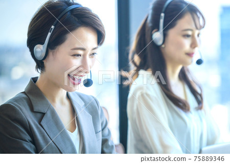 Middle operator who wears a headset in the office Middle operator who wears a headset in the office 75889346