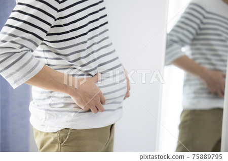 Middle-aged man who cares about proportions in front of the mirror Middle-aged man who cares about proportions in front of the mirror 75889795