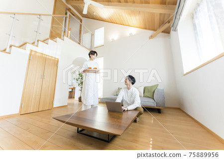 A man teleworking in the atrium living room 75889956