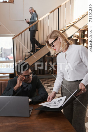 Business colleagues discussing document Business colleagues discussing document 75891289
