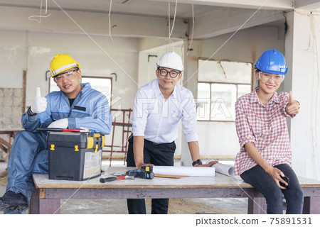 Construction engineer teamwork Safety Suit Trust Team Holding White Yellow Safety hard hat Security Equipment on Construction Site. Hardhat Protect Head for Civil Construction Engineer Concept 75891531