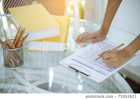 Woman working business office desk using laptop work from home. Businesswoman looking financial business chart, graph, infographic analyze sale statistics. Woman hands on entrepreneur office desk 75891621