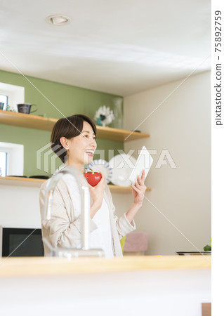 Housewife watching menu app on tablet Housewife watching menu app on tablet 75892759