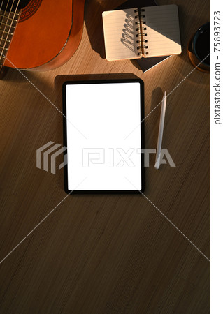 Digital tablet, notebook and acoustic guitar on wooden floor. Digital tablet, notebook and acoustic guitar on wooden floor. 75893723
