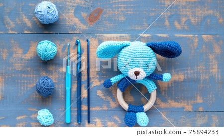 Knitted blue toy for kids on the table Knitted blue toy for kids on the table 75894233