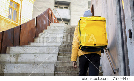 Food delivery man with yellow backpack Food delivery man with yellow backpack 75894454