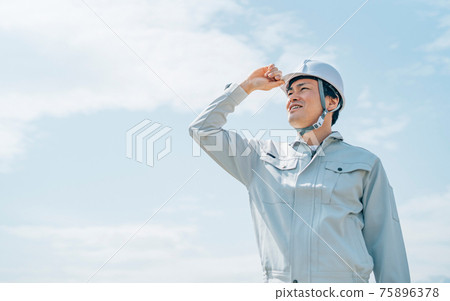 A man in blue sky and work clothes 75896378