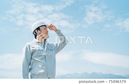 一個穿著藍天和工作服的男人 75896379