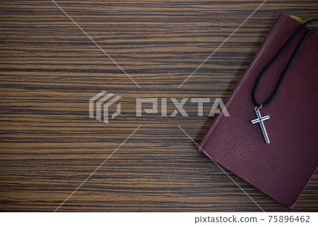 Crosses and book on a wooden table 75896462