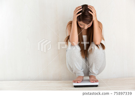 Woman measuring weight 75897339