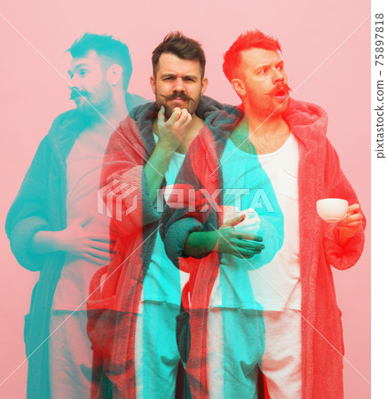 Young man in gray bathrobe isolated on pink background with glitch effect. 75897818