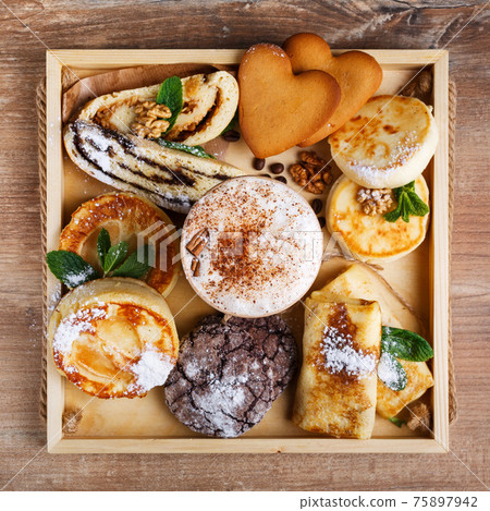 Cinnamon coffee and homemade chocolate cookies, strudel and mint cheeses. Handmade desserts and coffee in paper cup on brown rustic wooden background. 75897942