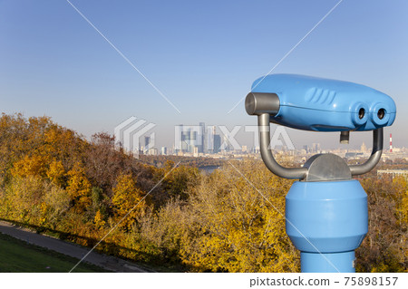 Touristic telescope viewer (binoculars) and view of central Moscow from Sparrow Hills or Vorobyovy Gory observation (viewing) platform-- is on a steep bank 85 m above the Moskva river, or 200 m above 75898157