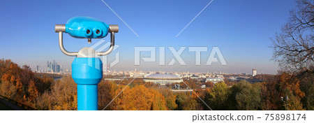 Touristic telescope viewer (binoculars) and Panoramic view of Sparrow Hills or Vorobyovy Gory observation (viewing) platform-- is on a steep bank 85 m above the Moskva river, or 200 m above sea level. Touristic telescope viewer (binoculars) and Panoramic view of Sparrow Hills or Vorobyovy Gory observation (viewing) platform-- is on a steep bank 85 m above the Moskva river, or 200 m above sea level. 75898174
