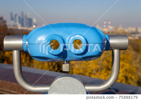 Touristic telescope viewer (binoculars) and view of central Moscow from Sparrow Hills or Vorobyovy Gory observation (viewing) platform-- is on a steep bank 85 m above the Moskva river, or 200 m above 75898179