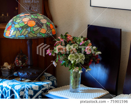 Interior photo with stained glass desk lamp and flower arrangement of Christmas rose Interior photo with stained glass desk lamp and flower arrangement of Christmas rose 75901596