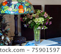 Interior interior with Christmas rose flower arrangement and stained glass desk lamp 75901597