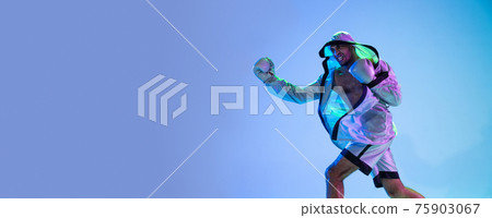 High-fashion styled man in white outfit pacticing box isolted over gradient background in neon light High-fashion styled man in white outfit pacticing box isolted over gradient background in neon light 75903067