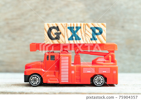 Fire ladder truck hold letter block in word GXP on wood background Fire ladder truck hold letter block in word GXP on wood background 75904357