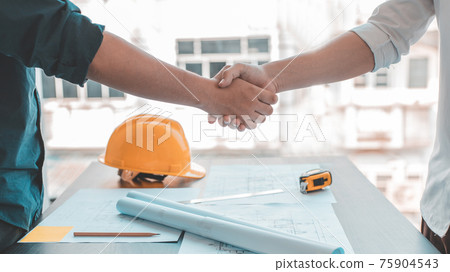 Men shake hands after the deal is done, Architects and engineers join hands to congratulate them after the building site meeting is completed, Symbol of friendship in business of both parties. 75904543