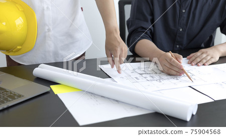 Meeting of engineers and architects in building planning, Consulting and brainstorming experts in architectural planning using blueprints, tape measure, rulers, laptop in designing buildings. Meeting of engineers and architects in building planning, Consulting and brainstorming experts in architectural planning using blueprints, tape measure, rulers, laptop in designing buildings. 75904568