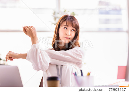 Woman stretching during desk work Woman stretching during desk work 75905317