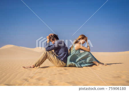 Relationship problems between a couple - a man and a woman. Family conflict. Man and woman have a heated relationship, sit in the hot desert with their backs to each other and do not want to talk Relationship problems between a couple - a man and a woman. Family conflict. Man and woman have a heated relationship, sit in the hot desert with their backs to each other and do not want to talk 75906180