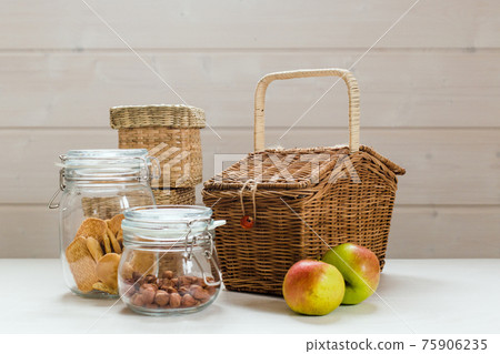 Glass cans with nuts and cookies and apples on wooden table, zero waste picnic concept Glass cans with nuts and cookies and apples on wooden table, zero waste picnic concept 75906235