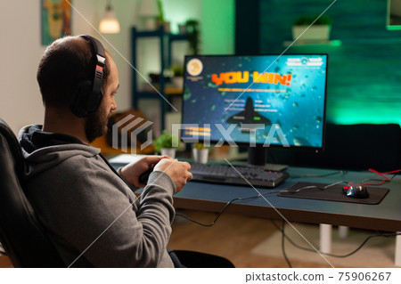 Back shot of pro gamer playing online shooter game 75906267