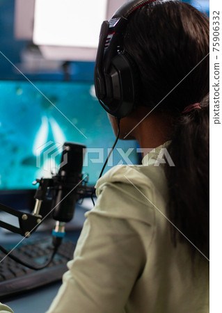 Dark skinned online e sport player talking into microphone Dark skinned online e sport player talking into microphone 75906332