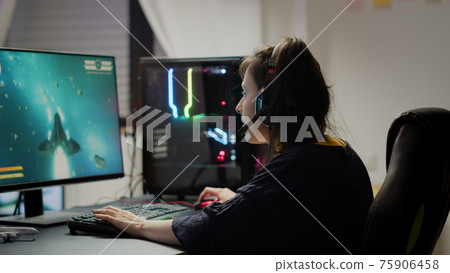 Pro woman video game r using headset playing online space shooter video games 75906458