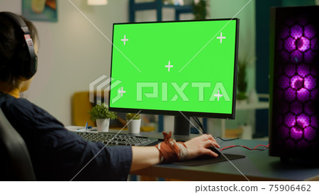 Woman streaming online video games on powerful computer with green screen Woman streaming online video games on powerful computer with green screen 75906462