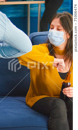 Cheerful friends touching elbow keeping social distancing greeting 75906474